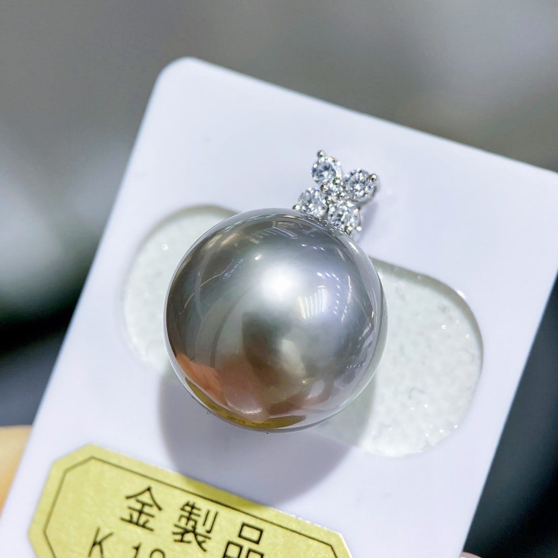 Fine 18K White Gold Gray Pearl Pendant: This pendant is crafted in 18K white gold, featuring a 14.3mm perfectly round gray pearl with slightly flawed high quality. The platinum gray hue of the pearl is bright and charming, making it a refre