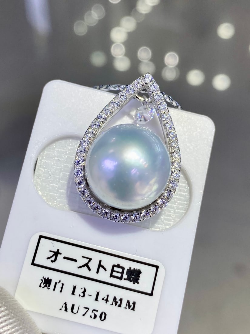 Sterling Silver Australian White Pearl Pendant 13-14mm: This pendant features a large Australian white pearl as the main stone, showcasing a satin-like cool light texture. The perfectly round shape of the pearl complements the K gold craftsmanship, exuding