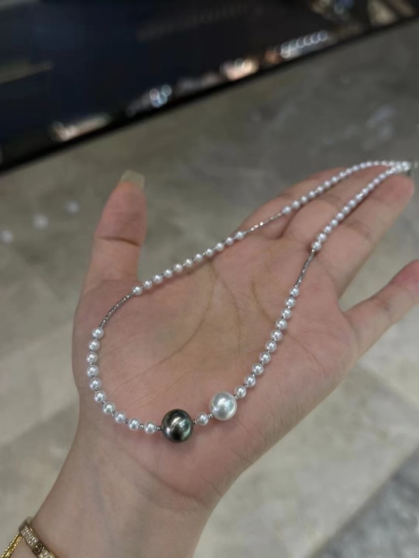 18K Gold Pearl Necklace: This 18K gold pearl necklace combines Tahitian black pearls with Akoya Japanese seawater pearls, showcasing a perfect blend of elegance and luxury. The luster of the pearls complements the brilliance