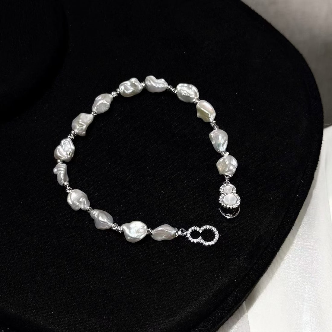 Baroque Pearl Bracelet: This bracelet features 6-7mm high-luster, slightly blemished baroque freshwater pearls, complemented by a natural shell inlaid gourd clasp, showcasing a unique design style. Each pearl has a unique sh