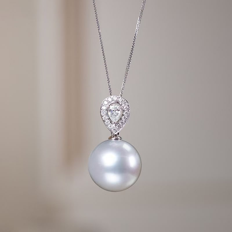 18K Gold Australian White Pearl Pendant: This pendant is crafted in 18K gold, set with diamonds and features an Australian white pearl, showcasing an elegant silky luster. The pearl is moderately sized, offering a subtle presence suitable fo