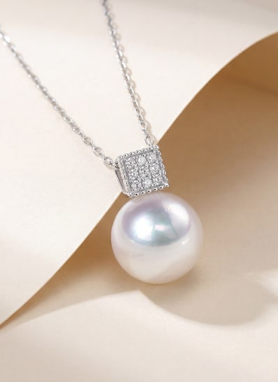 18K Gold Slightly Blemished Akoya Pearl Pendant: This pendant is crafted from 18K gold and features a subtly flawed Akoya pearl with exceptional luster, showcasing a classic and elegant style. The pendant tassel is fully set with diamonds, adding a 