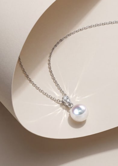 18K Gold Slightly Blemished Akoya Pearl Pendant: This pendant is meticulously crafted in 18K gold, featuring a slightly blemished Akoya pearl with an exceptionally bright luster, exuding an elegant aura. The roundness of the pearl complements the br