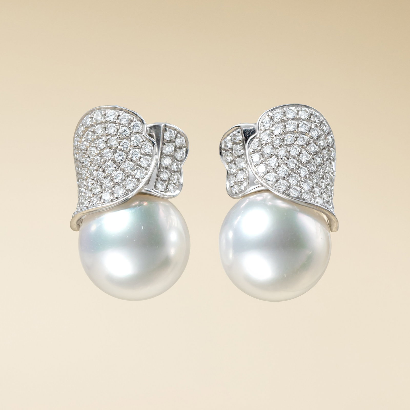 18K Gold South Sea White Pearl Earrings: These earrings are meticulously crafted in 18K gold, featuring South Sea white pearls that perfectly combine elegance and luxury. The lustrous pearls complement the brilliance of the diamonds, making 