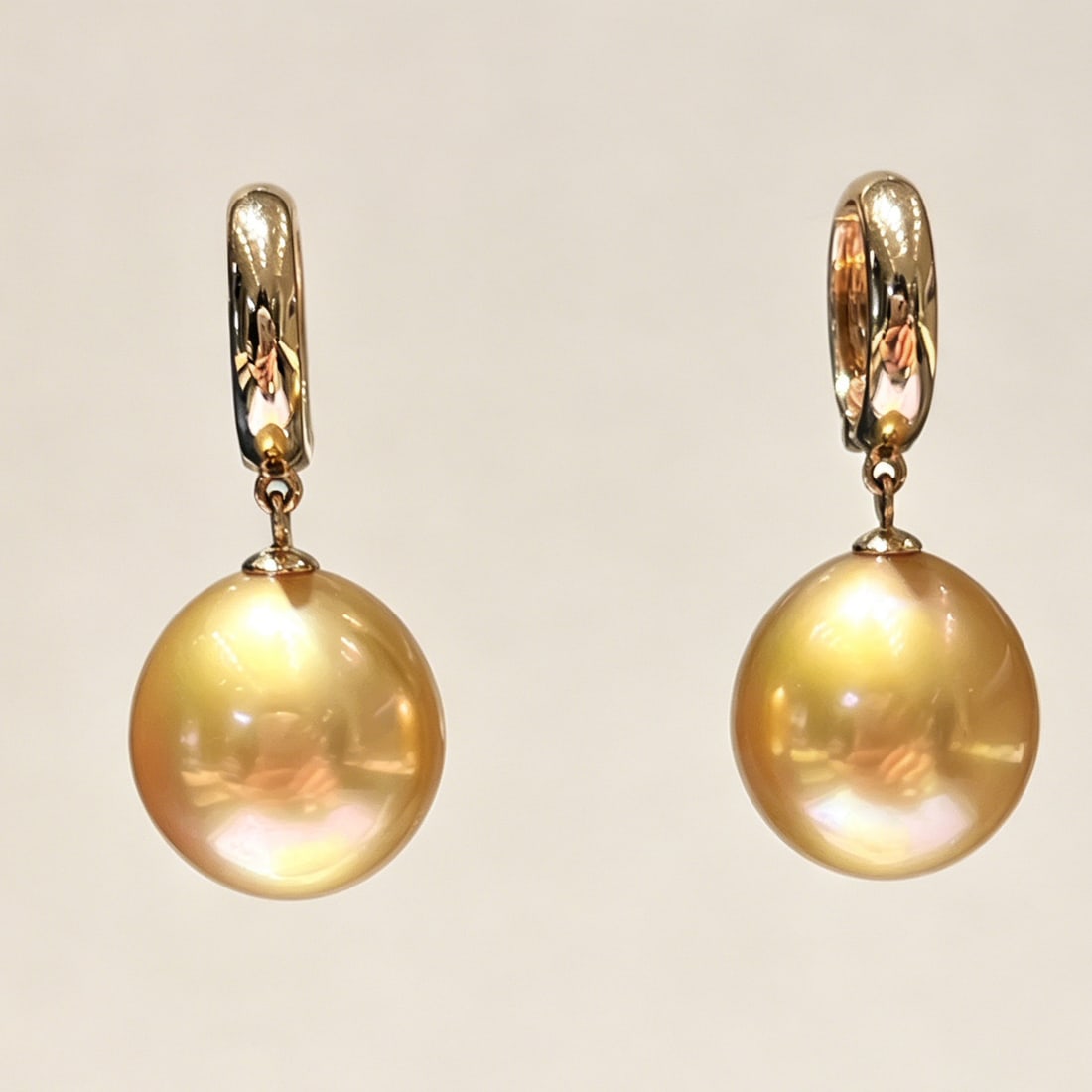 18K Gold South Sea Golden Pearl Earrings: These earrings are meticulously crafted from 18K gold, featuring South Sea golden pearls that exude an aura of elegance and nobility. The near-round shape of the pearls complements their golden luster
