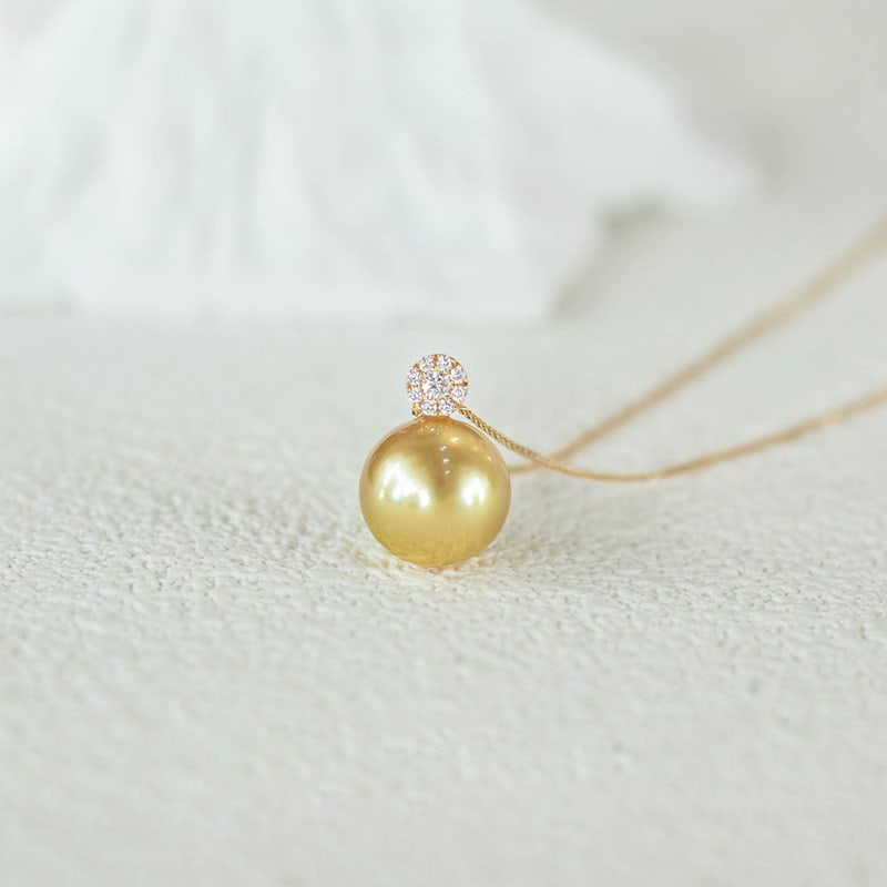18K Gold South Sea Golden Pearl Pendant: This pendant necklace is meticulously crafted in 18K gold, featuring a South Sea golden pearl that exudes noble elegance. The luster of the pearl complements the brilliance of the diamonds, perfectly 