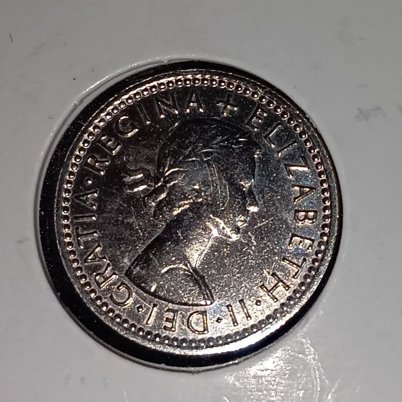 1964 Queen Elizabeth II "Happy Sixpence" Coin Issued in the United Kingdom: This is a 1964 British copper-nickel alloy coin, featuring a portrait of Queen Elizabeth II on the obverse and a floral design on the reverse. Year: 1964 Country: United Kingdom Material: Copper-nicke