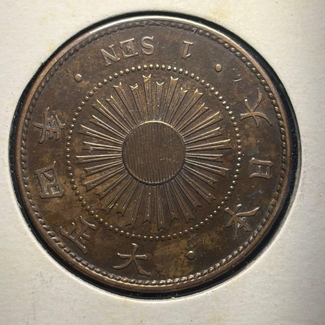 This is a "1 Sen Copper Coin" issued in 1915 (Taisho 4).: This is a 1915 (Taisho 4) issued "1 Sen Copper Coin" Product Details Coin: 1 Sen Copper Coin Year of Issue: Taisho 4 (1915) Condition: As shown in the image, due to its age (antique patina), there is 