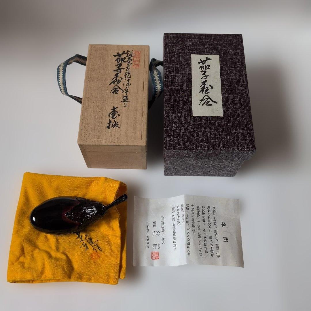 Wajima lacquerware, handcrafted by lacquer artist Kawagishi Mitsumasa, utilizing the Wajima dry: This is a finely crafted hand-made Wajima lacquer eggplant-shaped incense box, created by lacquer artist Kawagishi Mitsumasa using the Wajima dry lacquer technique. It comes with its original box and 