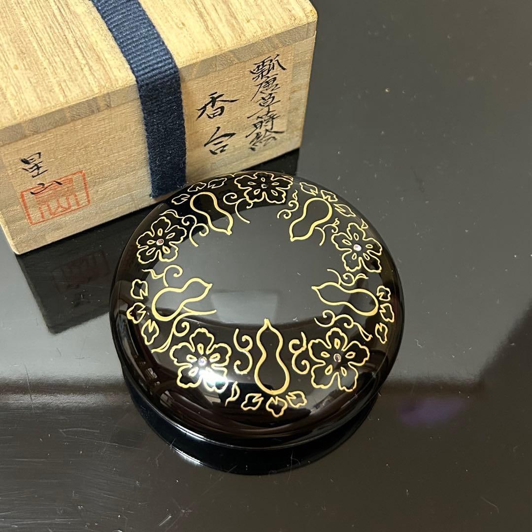 This is a flat, circular incense box. - 2