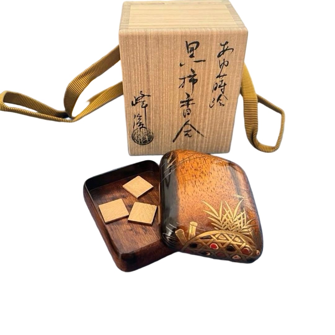 A black persimmon wood incense box designed by Sakata Mineharu, decorated with a sweetfish maki-e (1 of 10)
