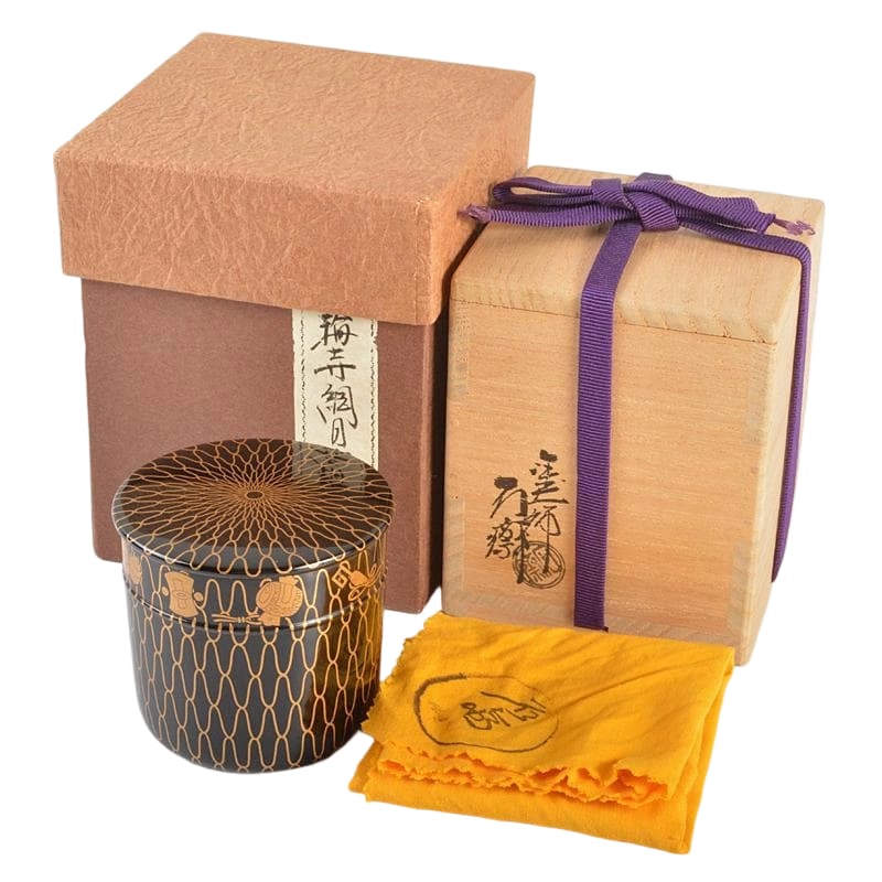 Yamanaka Lacquerware, crafted by lacquer artist Tsuji Sekisai, featuring maki-e (gold lacquer) net: Yamanaka Lacquerware, crafted by lacquer artist Tsuji Sekisai, featuring maki-e (gold lacquer) net pattern treasure motif, in the style of Kinrin-ji, tea caddy, accompanied by matching cloth and box. 