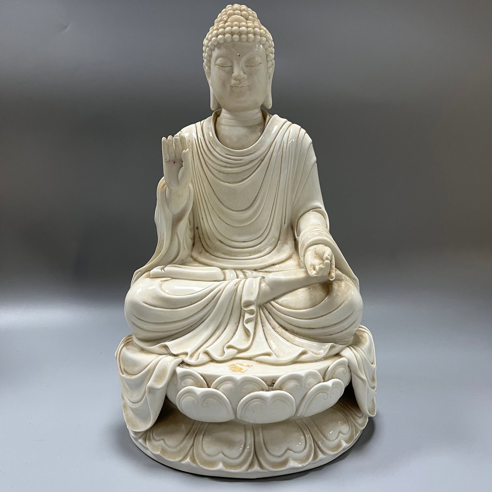 Dehua kiln white porcelain Shakyamuni statue: A Dehua ware white porcelain Shakyamuni Buddha statue, 41 x 22 cm. The entire piece is covered in an ivory-white glaze, the glaze itself lustrous and smooth like solidified fat, exhibiting the unique