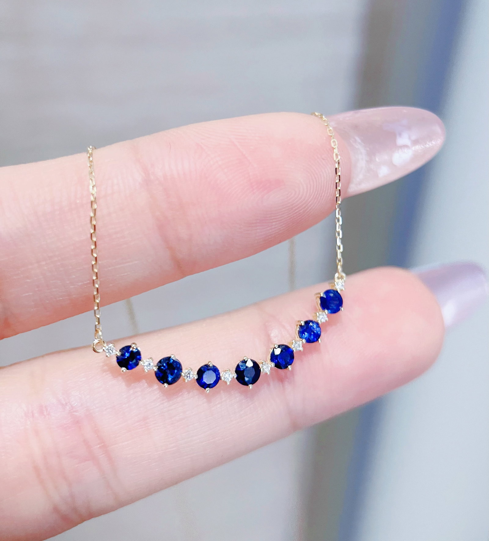 18K Gold Natural Sapphire Necklace: This necklace features 18K gold set with natural sapphires, showcasing a serene deep blue reminiscent of a starry river. It exudes understated elegance, perfectly outlining the gentle curve of the col