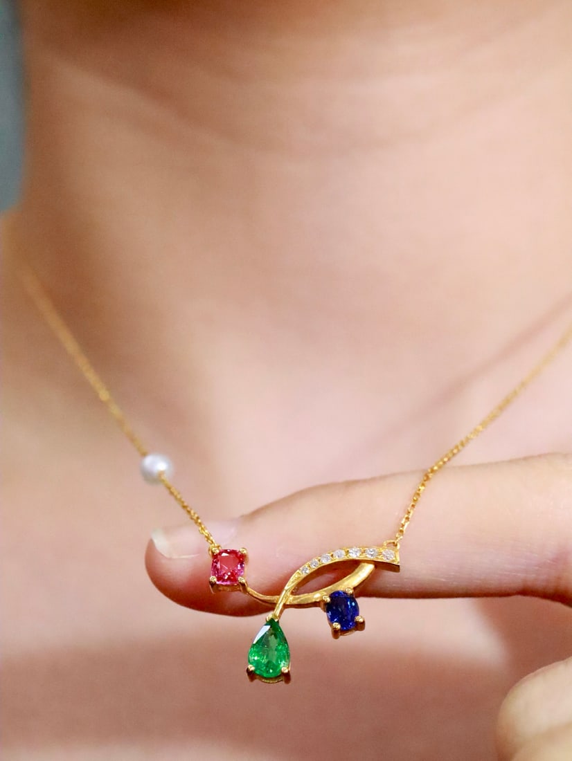 18K Gold Natural Multi-Gemstone Collarbone Necklace: This collarbone necklace is crafted from 18K gold, skillfully set with three different gemstones, showcasing a variety of colorful charms. The small pearl on the chain adds an elegant touch, suitable
