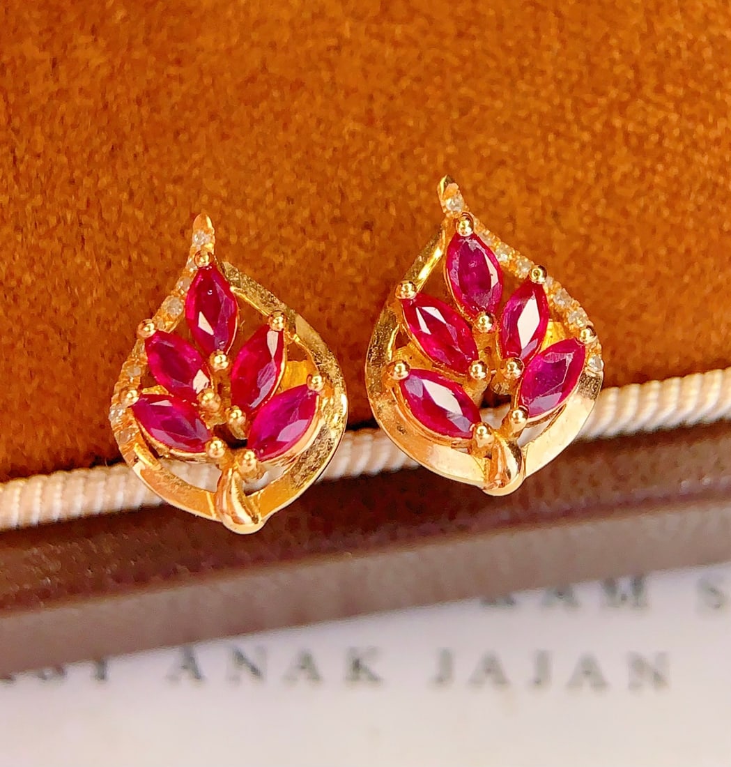 18K Gold Natural Ruby Earrings: These earrings are meticulously crafted in 18K gold, featuring natural rubies that exude an elegant and noble aura. The main stone is a 2-carat ruby, surrounded by 20 diamonds, adding a brilliant