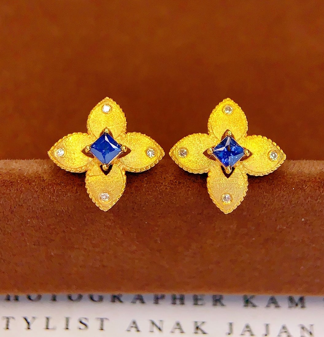 18K Gold Natural Sapphire Earrings: These earrings are meticulously crafted in 18K gold, set with natural sapphires that exude a captivating brilliance. The deep hue of the sapphires complements the dazzling diamonds, perfectly