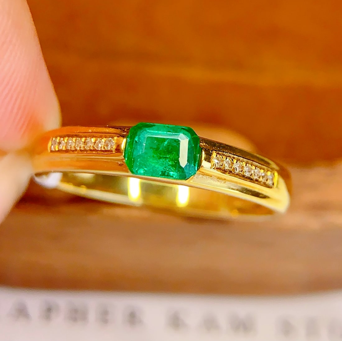 18K Gold Natural Emerald Ring: This ring is meticulously crafted in 18K gold, set with a natural emerald, exuding an aura of elegance and nobility. The main stone is a 0.45-carat emerald, surrounded by 14 diamonds that add a