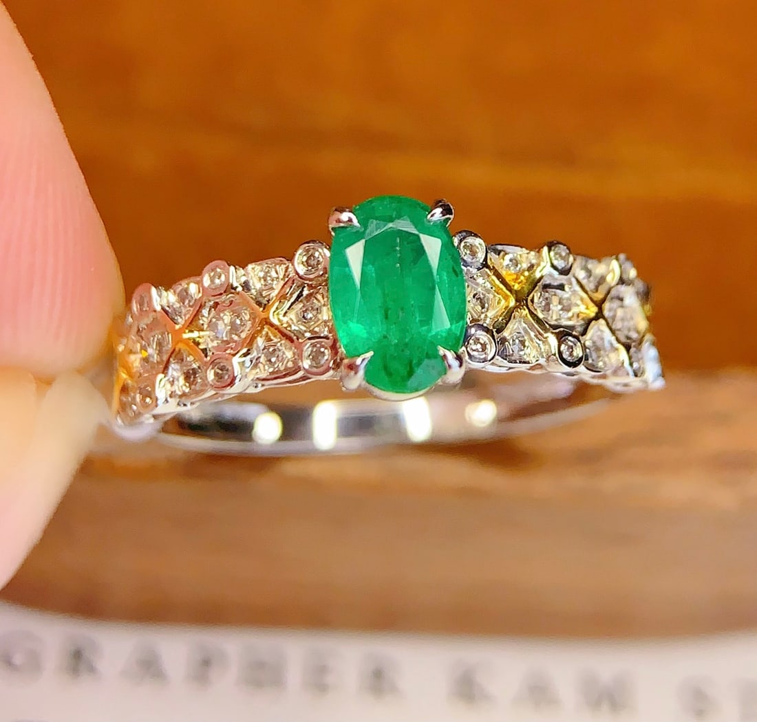 18K Gold Natural Emerald Ring: This ring is meticulously crafted in 18K gold, set with a natural emerald, exuding an aura of elegance and nobility. The main stone is a 0.6-carat emerald, surrounded by 40 sparkling diamonds, adding 