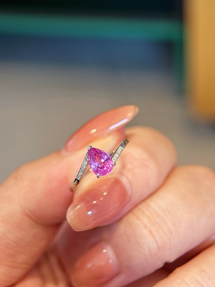 18K Gold Natural Pink Sapphire Diamond Ring: This ring features a pear-shaped cut pink sapphire as the main stone, showcasing a transparent and lively brilliance. The double band is adorned with fine diamonds, offering a simple yet exquisite des