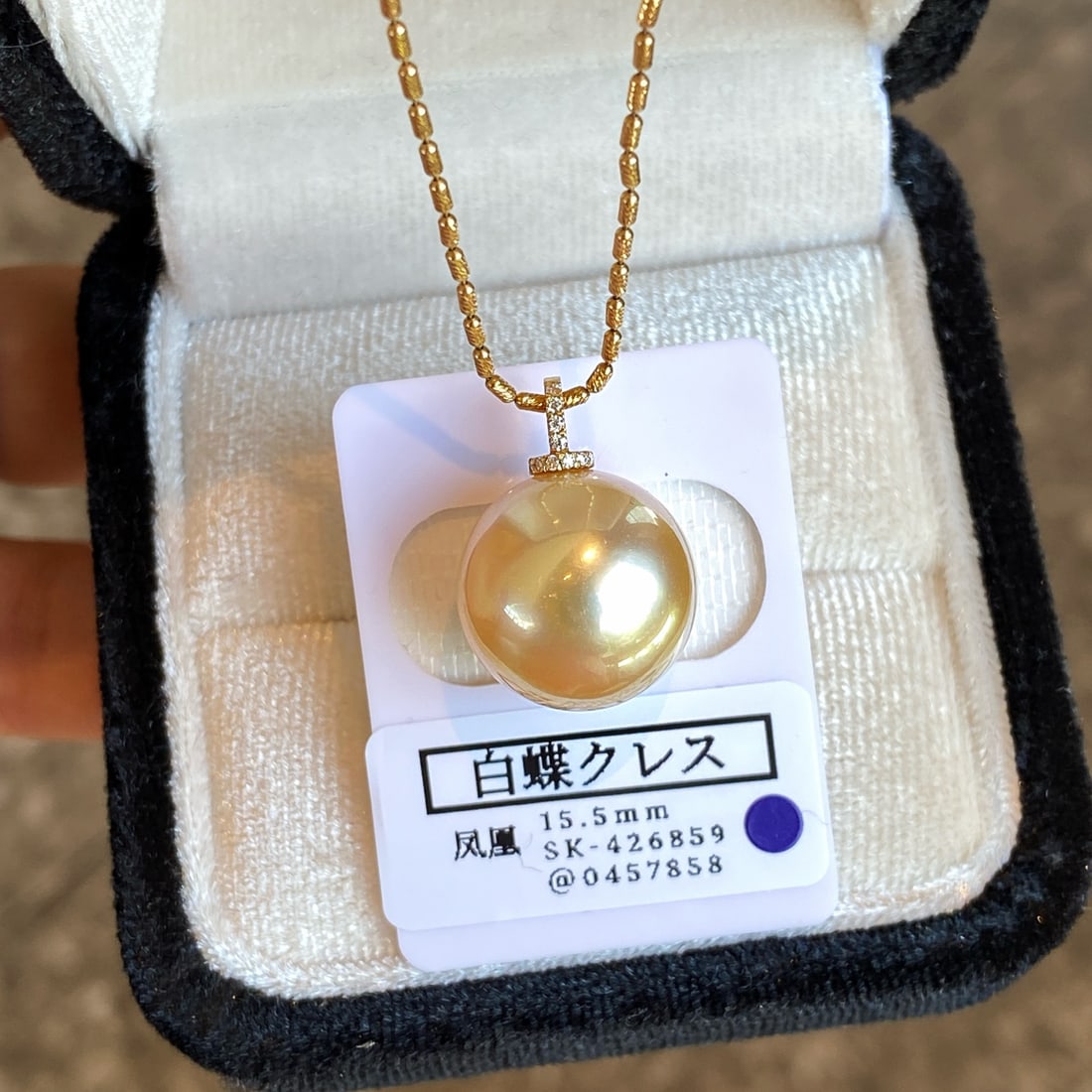 18K Gold Natural White South Sea Pearl Pendant: This pendant is meticulously crafted in 18K gold, featuring a 15.5mm white South Sea pearl with extremely slight blemishes, appearing nearly flawless. The golden luster of the pearl complements Asian 