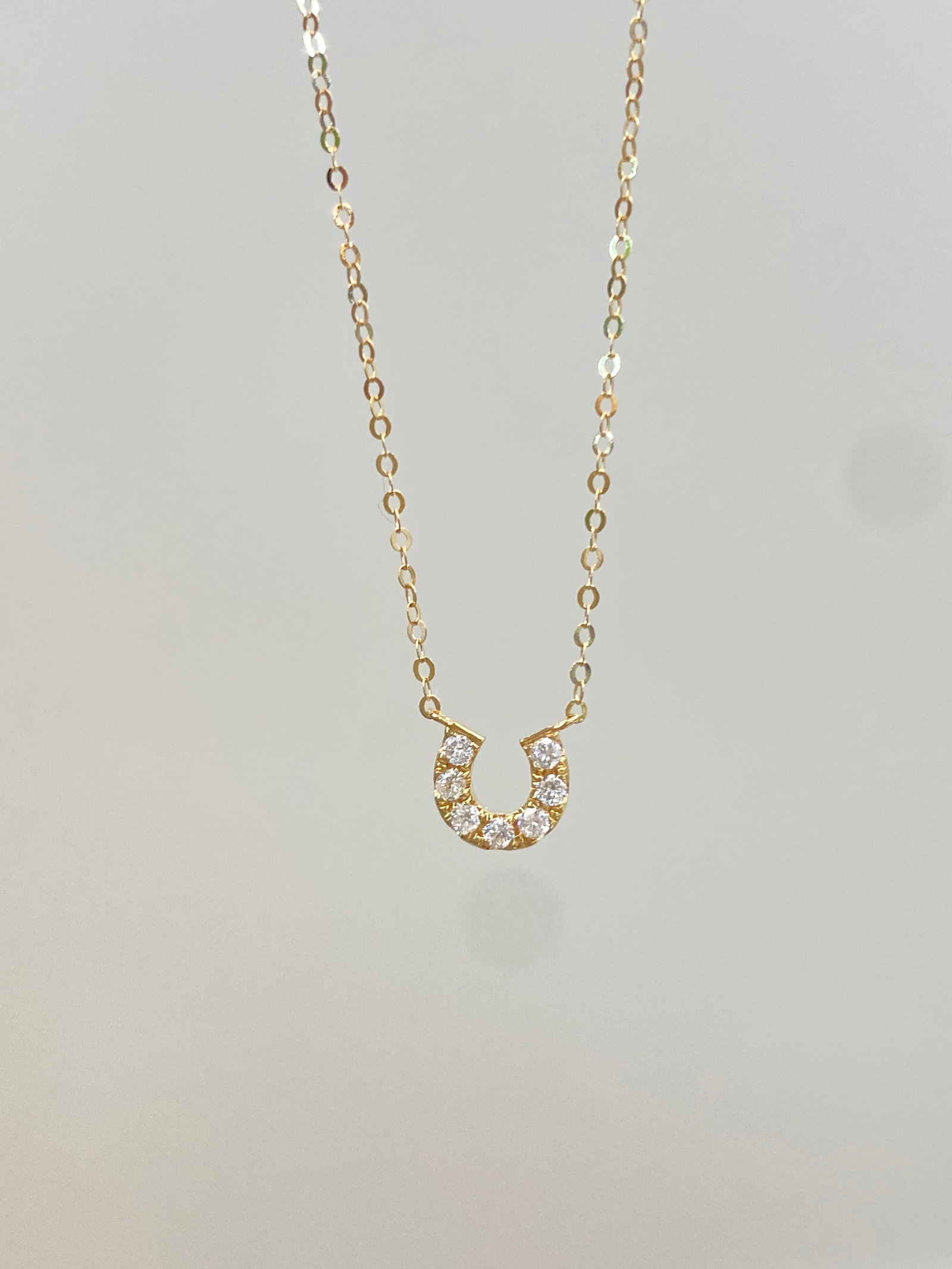 18K Gold Natural Diamond Necklace: This 18K gold necklace features a three-dimensional U-shaped horseshoe design, with a delicate contour that rests perfectly on the collarbone, exuding minimalist elegance. Set with natural diamonds, i