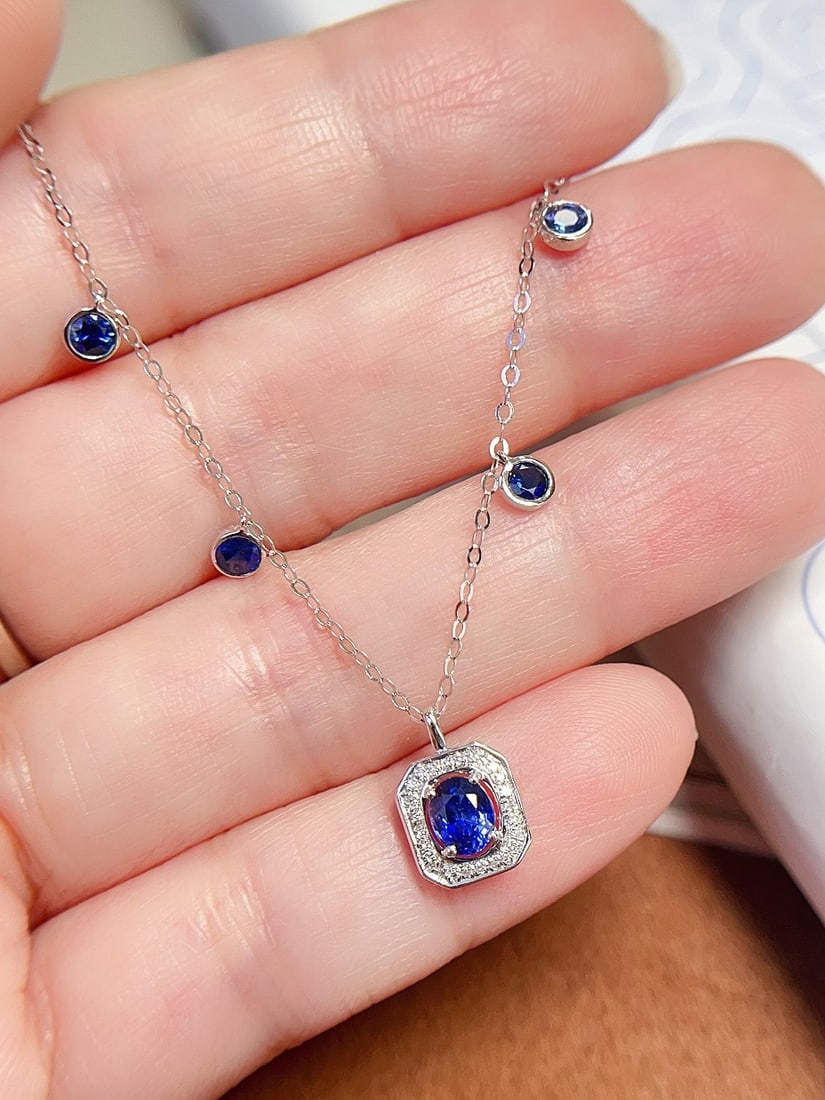 18K Gold Royal Blue Sapphire Necklace: This necklace is crafted in 18K gold, featuring a royal blue sapphire that exudes a fresh and elegant design. The main stone is approximately 0.36 carats, surrounded by 26 diamonds, creating a delicat