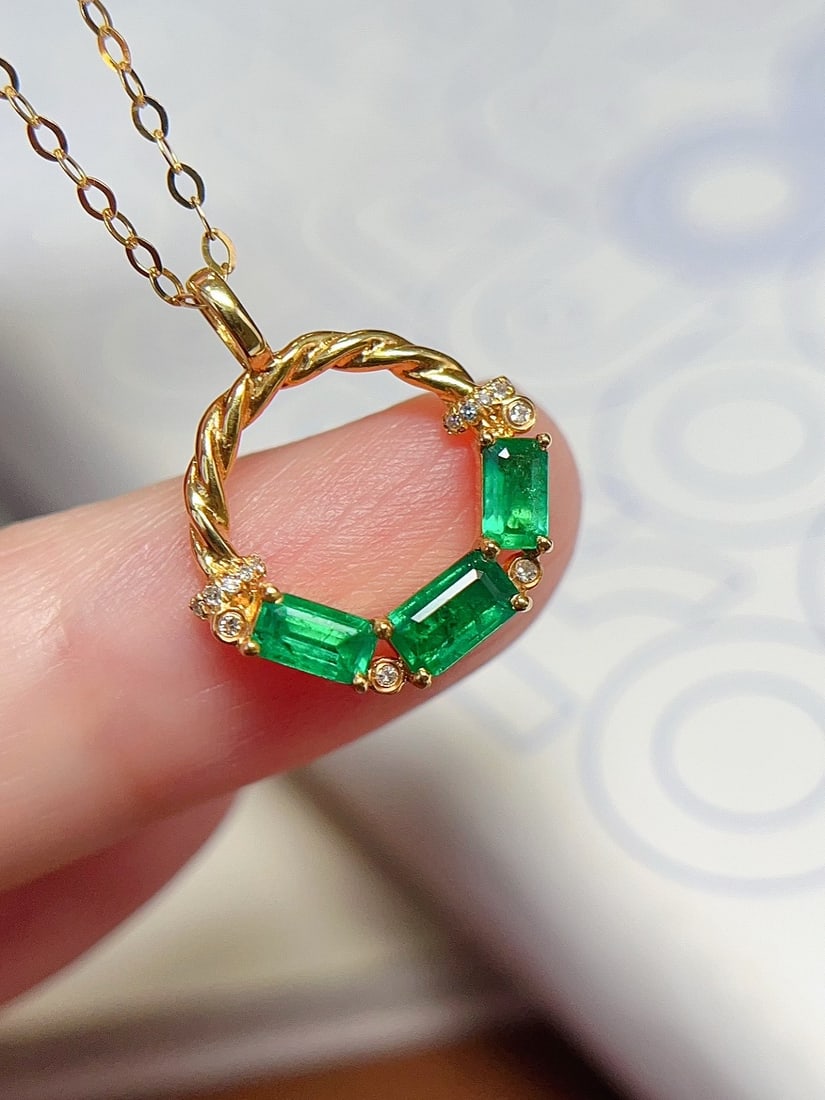 18K Gold Emerald Necklace: This 18K gold necklace features a bright emerald, showcasing a captivating luster. The rich hue of the emerald is complemented by 14 sparkling diamonds, creating an elegant and exquisite design. (Main