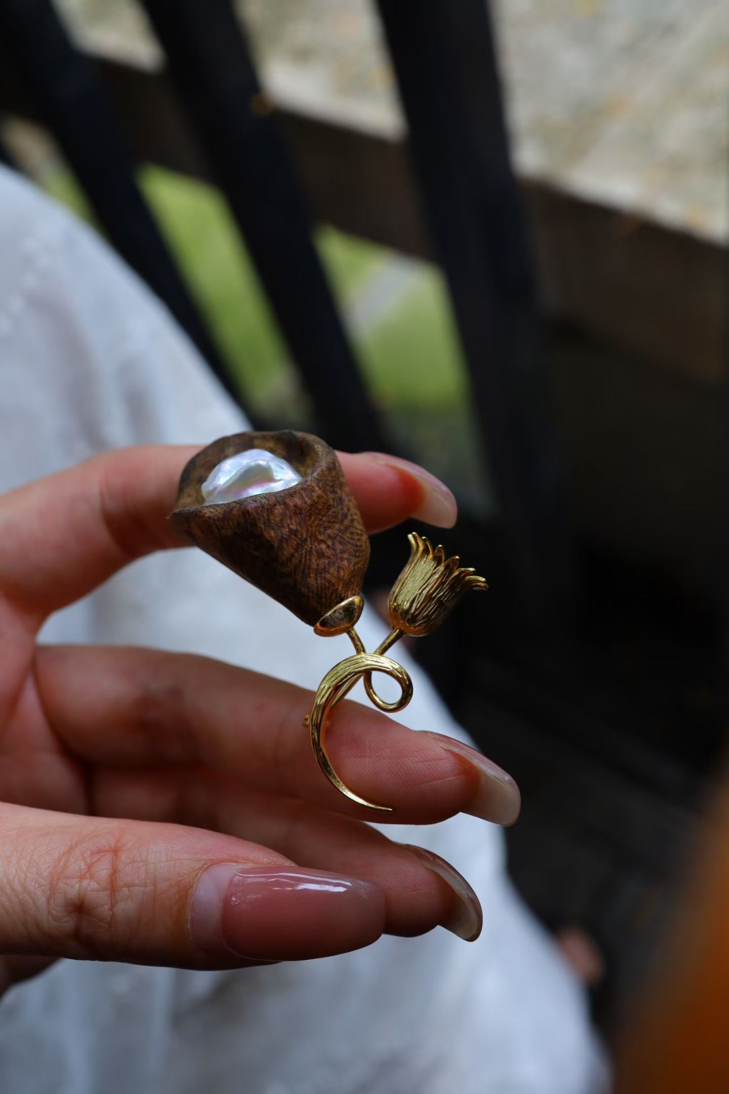 Natural Irregular Pearl Brooch: This brooch features a natural irregular pearl, showcasing a unique natural beauty. The luster of the pearl complements the texture of the agarwood, exuding a subtle elegance when worn.
