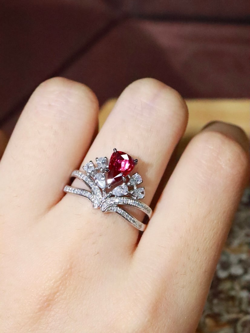 Platinum Unheated Ruby Ring: This ring features a vintage crown design, showcasing the natural allure of the unheated ruby. The pear-shaped ruby complements the brilliant diamonds, with the band adorned with sparkling stones,