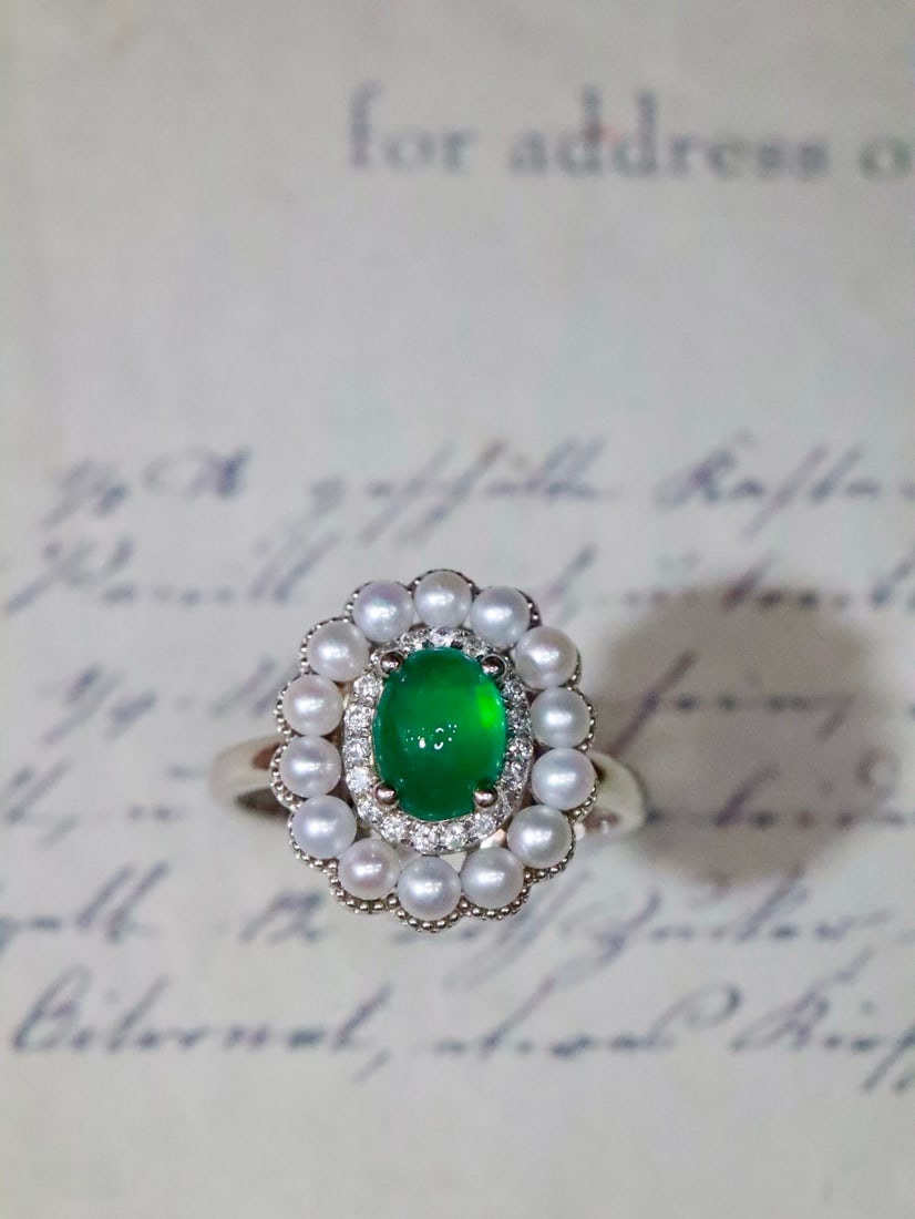 18K Gold Emerald Ring: This 18K gold emerald ring combines exquisite craftsmanship with a pearl main stone, exuding a noble aura. The deep hue of the emerald complements the brilliance of the diamonds, perfectly showcasing