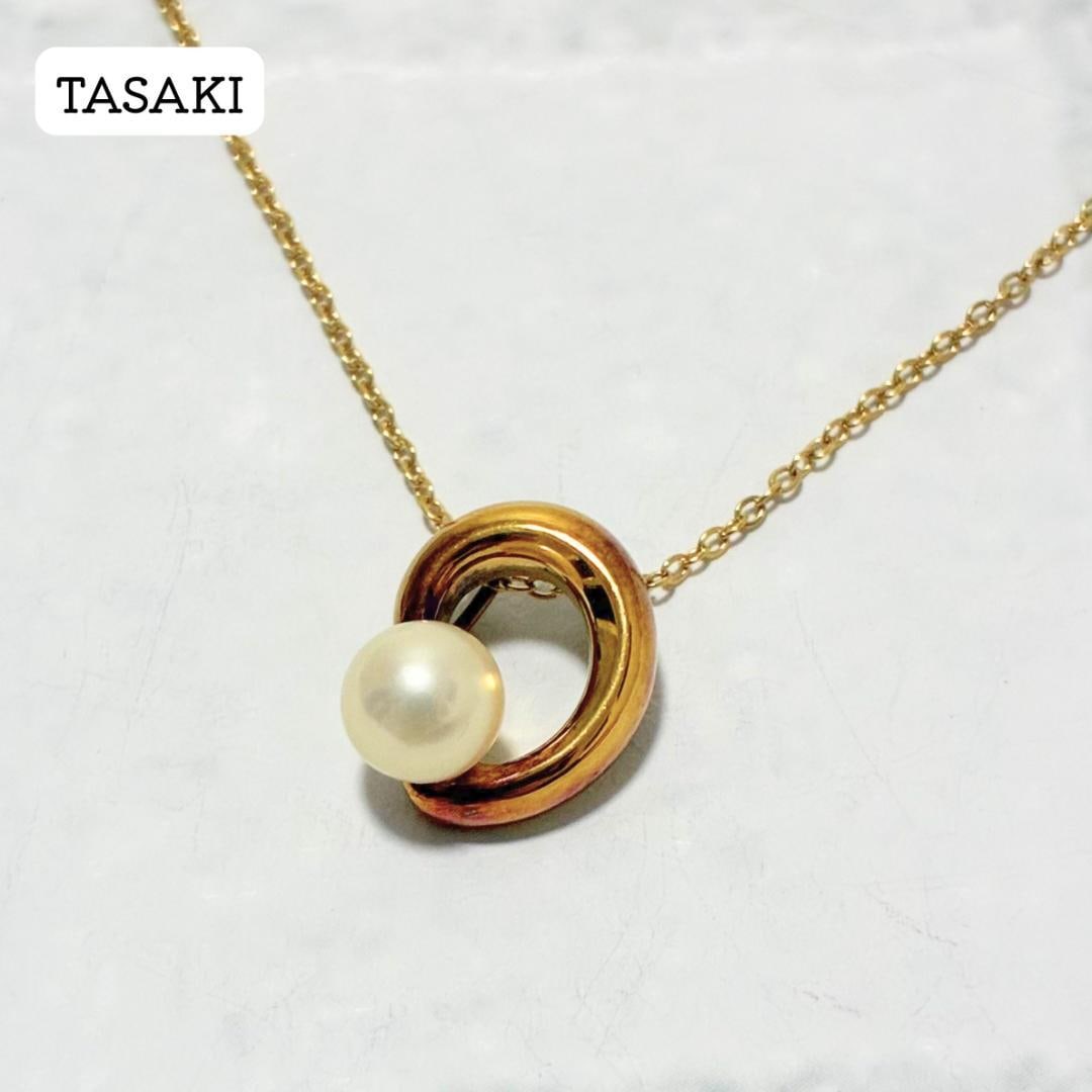 Second-hand - TASAKI necklace, gold color, single pearl, round loop, silver engraving.: TASAKI necklace, featuring a circular design with a single pearl, in gold and silver engraving, with Akoya pearl. This TASAKI necklace is themed around a circular design, accented with a single pearl.