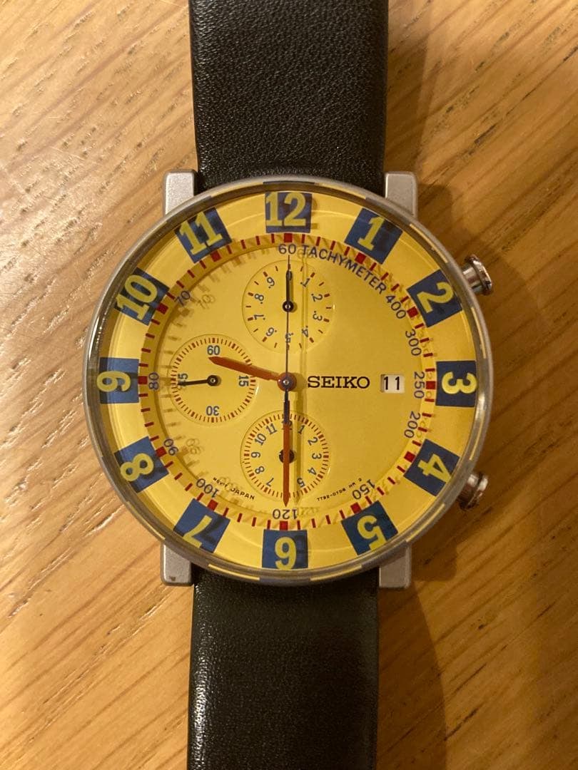 Second-hand - SEIKO SOTTSASS ASSOCIATES Limited Edition: This is a limited edition chronograph watch designed by Ettore Sottsass, featuring a vibrant yellow dial and a unique layout of markers. The client purchased it from an authorized SEIKO retailer and b