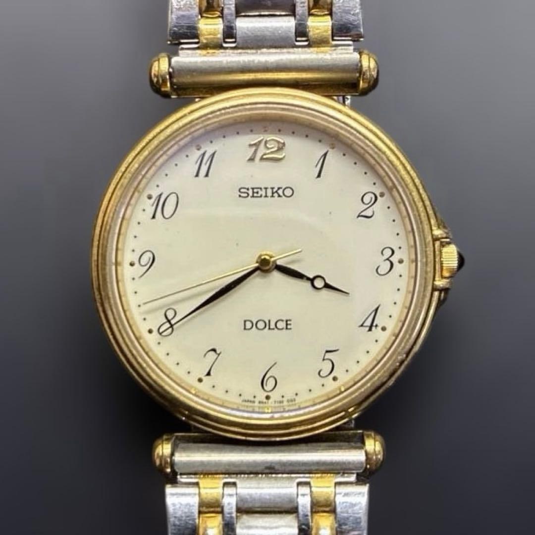 Second-hand - SEIKO DOLCE Quartz Watch Gold/Silver Made in Japan: This is a SEIKO DOLCE quartz wristwatch, featuring a combination of gold and silver colors with highly visible Arabic numeral markers. The back of the watch is engraved with a commemorative mark. The 