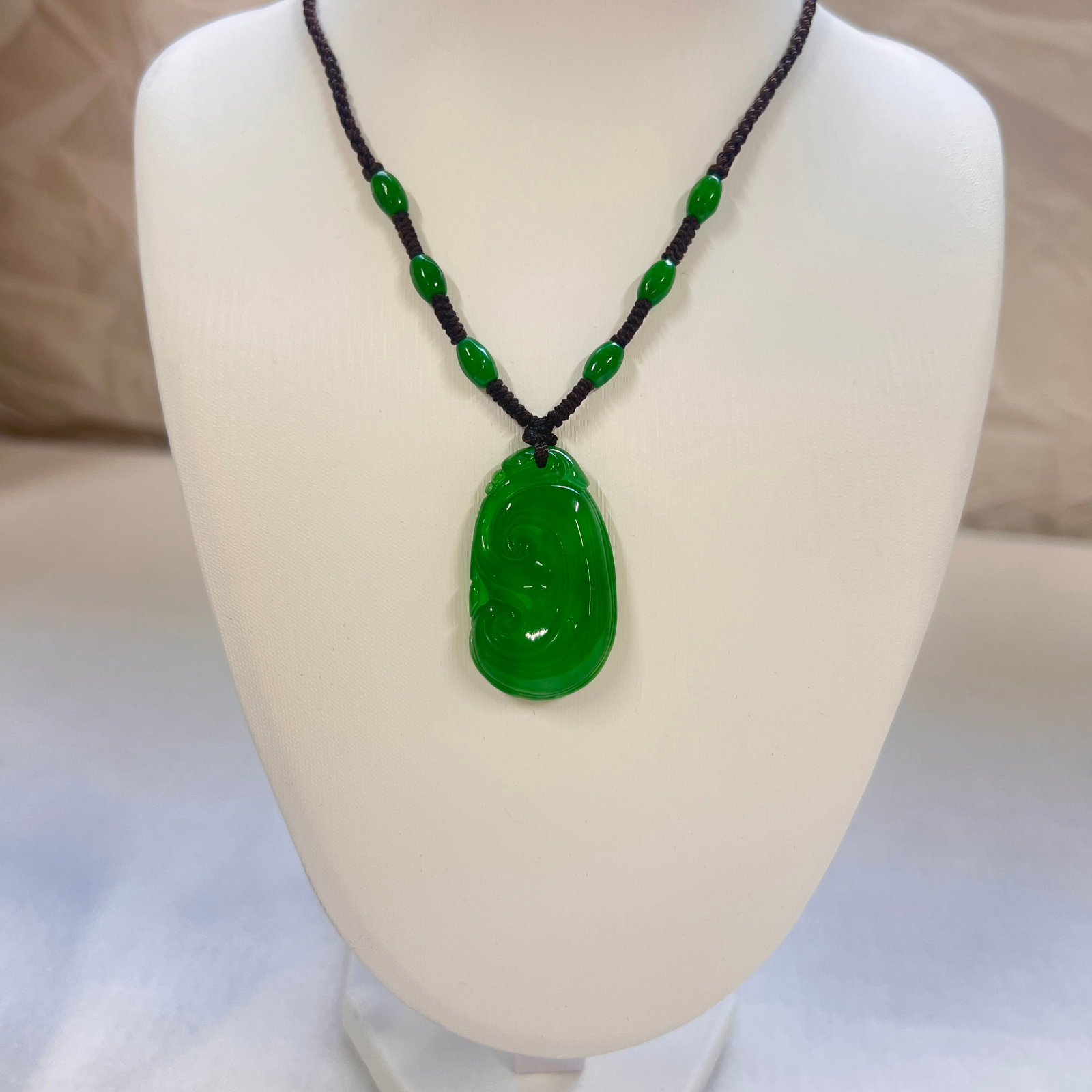 Natural Jadeite Pendant Necklace: This natural jadeite pendant necklace features a rich and vibrant emerald-green hue. The jade is highly translucent and lustrous, displaying a captivating glow and remarkable depth when illuminated. T