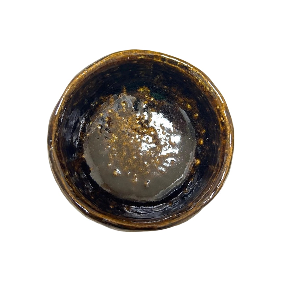 10th Generation Ohi Chozaemon, Ohi Toyasai, Ame-yu Chawan (Tea Bowl): This pottery piece is glazed with black and brown glazes, possessing a unique luster. The beautiful variation of the glaze is pleasing to view from any angle. Presence of an Inscription The bottom bea