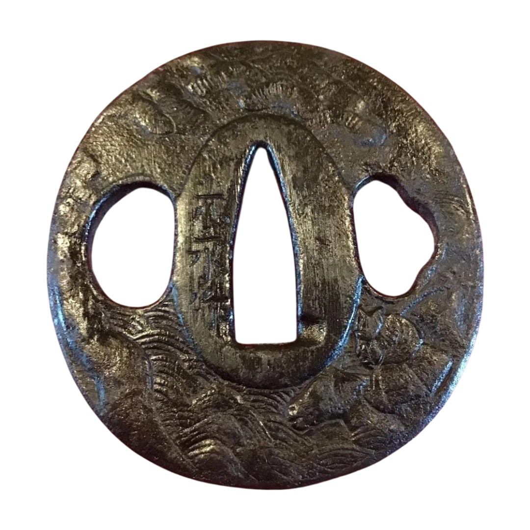 Iron ground, carved design of a warrior crossing a river, signed Mitsunaga-saku. Guaranteed from the: "Warrior Crossing the River" design, adorned with motifs of waves and horses, is a signed tsuba. Dimensions (mm): Height: 60 Width: 55 Thickness: 4 Material: Iron Design: Waves and Horses Shape: Circ
