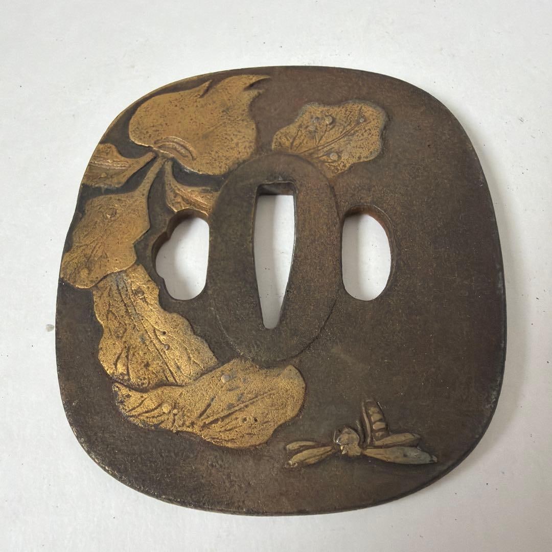 Iron Base Sword Guard: This is an iron tsuba used for the decoration of a Japanese sword, exquisitely depicting patterns of lotus leaves and dragonflies.