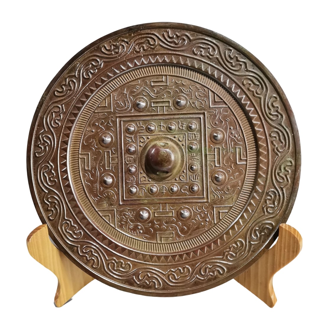 Bronze Mirror with Bosses: This bronze mirror with bosses exhibits a reddish-brown patina, indicating its long history and exquisite craftsmanship. The surface is adorned with finely crafted boss patterns, showcasing high