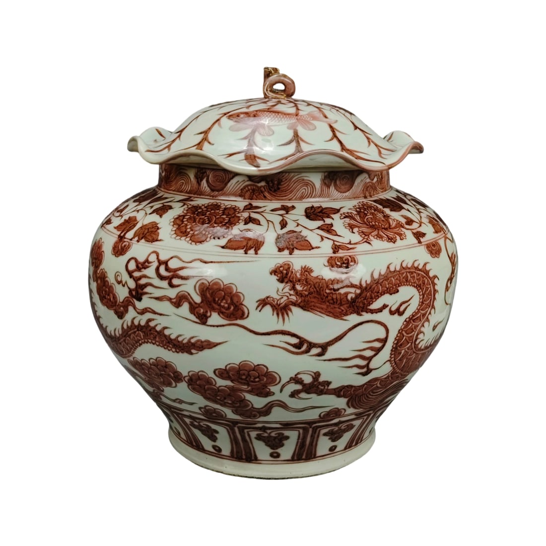 Ming Dynasty Underglaze Red Cloud and Dragon Pattern Lotus Leaf Lid Jar: This underglaze red cloud and dragon pattern lotus leaf lid jar is exquisitely crafted with intricate designs, showcasing the superb porcelain-making skills of the Ming Dynasty. The glaze is vibrant a