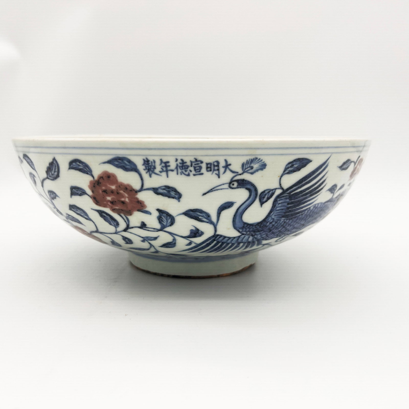 A large blue and white with underglaze red bowl featuring peacock and peony motifs, with a mark and: Large Blue and White Underglaze Red Peacock and Peony Pattern Bowl, Xuande Mark and Period Material: Blue and White Underglaze Dimensions: Diameter 28 cm, Height 11 cm, Weight 2470 g Price: Descriptio