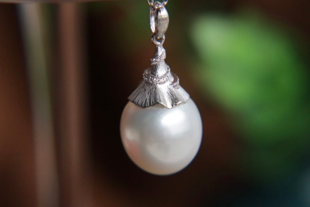 18K Gold Natural Australian White Sea Pearl Diamond Pendant: This pendant is meticulously set in 18K gold with Australian white sea pearl and sparkling diamonds, showcasing a radiant luster that exudes elegance. The delicate texture with micro-growth lines adds
