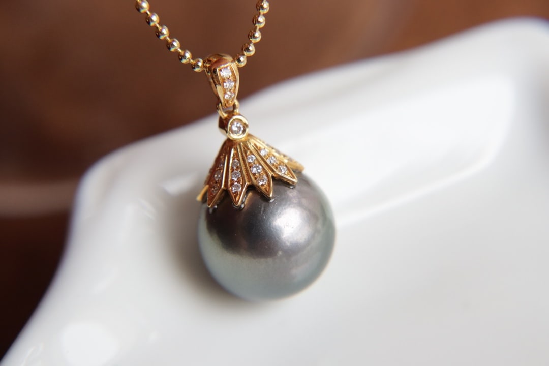 18K Gold Natural Pearl Pendant: This pendant is meticulously crafted in 18K gold, featuring a natural pearl with a diameter of 13mm. The pearl's surface is nearly flawless, showcasing a captivating luster and unique brilliance.