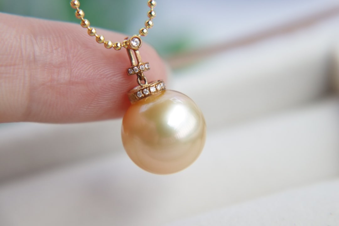 18K Gold Flawless Sea Water Golden Pearl Pendant: This 18K gold sea water golden pearl pendant features a pearl with a diameter of 12mm, showcasing a stunning color and brilliant luster, embodying unparalleled perfection. (Pearl diameter 12mm)