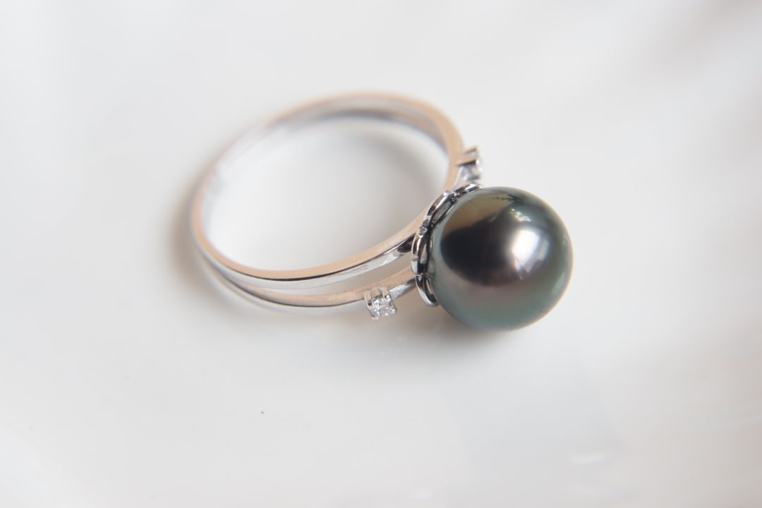 18K Gold Natural Tahitian Black Pearl Ring: This 18K gold ring features a natural Tahitian black pearl with a diameter of 9.5 to 10mm. The pearl's surface is delicate, with a strong luster and flawless perfection, showcasing unparalleled