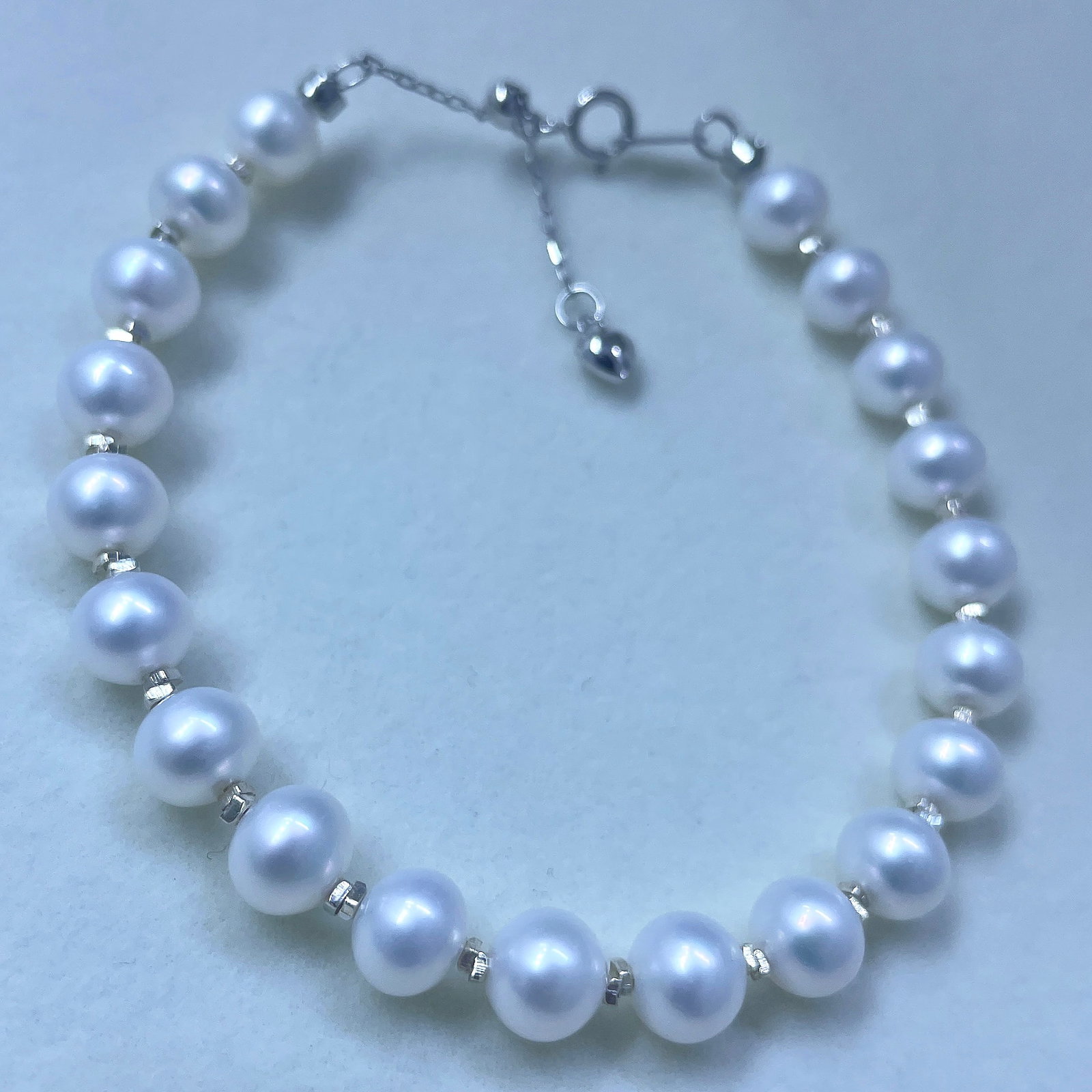 925 Silver Natural Freshwater Pearl Bracelet: This bracelet is made of 925 silver, featuring near-round freshwater pearls that showcase a simple yet stylish charm. The pearls have a strong luster and are nearly flawless, with a diameter of