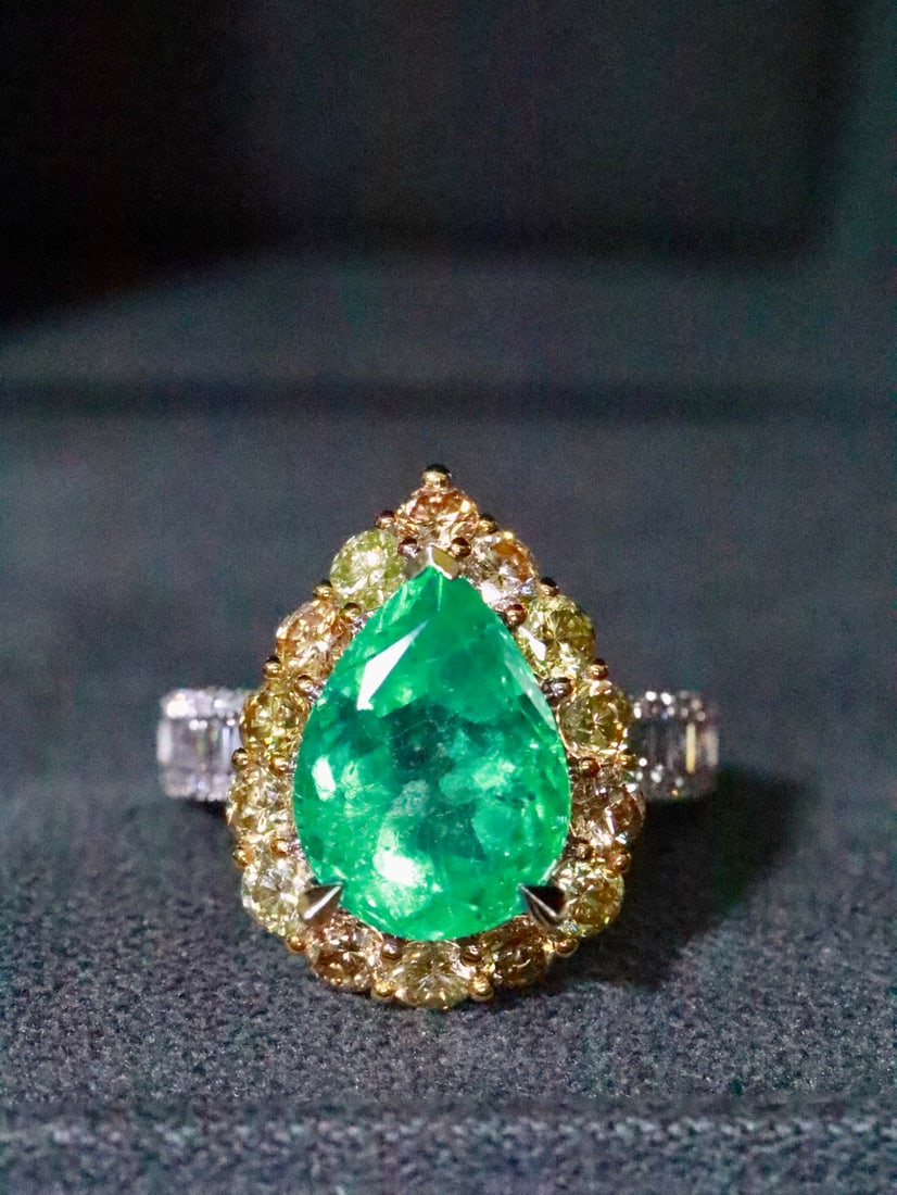 18K Natural Emerald Ring: This ring features a bright and full green emerald as the main stone, complemented by dazzling yellow diamonds that sparkle irresistibly. Its unique teardrop shape adds elegance and luxury. (Total wei
