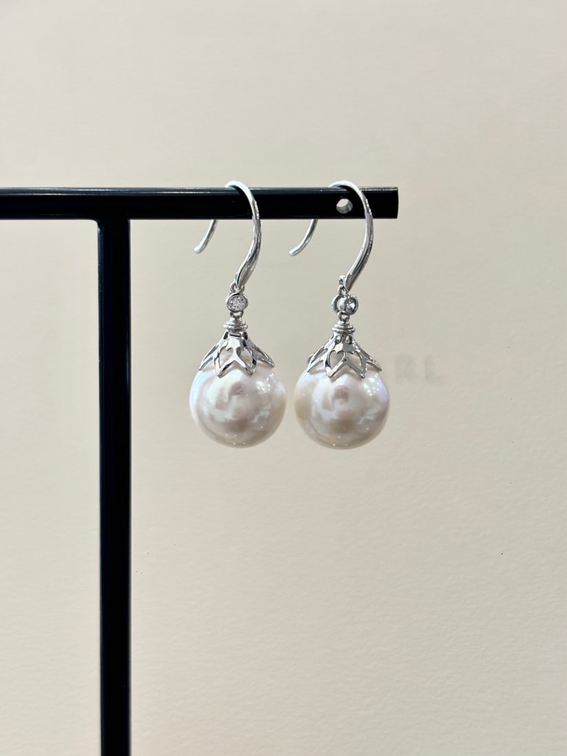 S925 Silver Strong Luster Freshwater Pearl Earrings: These earrings are crafted from S925 silver, featuring 12-13mm round freshwater pearls that exhibit a strong luster and elegant charm. The micro-growth lines add a unique natural appeal. (Pearl size 1