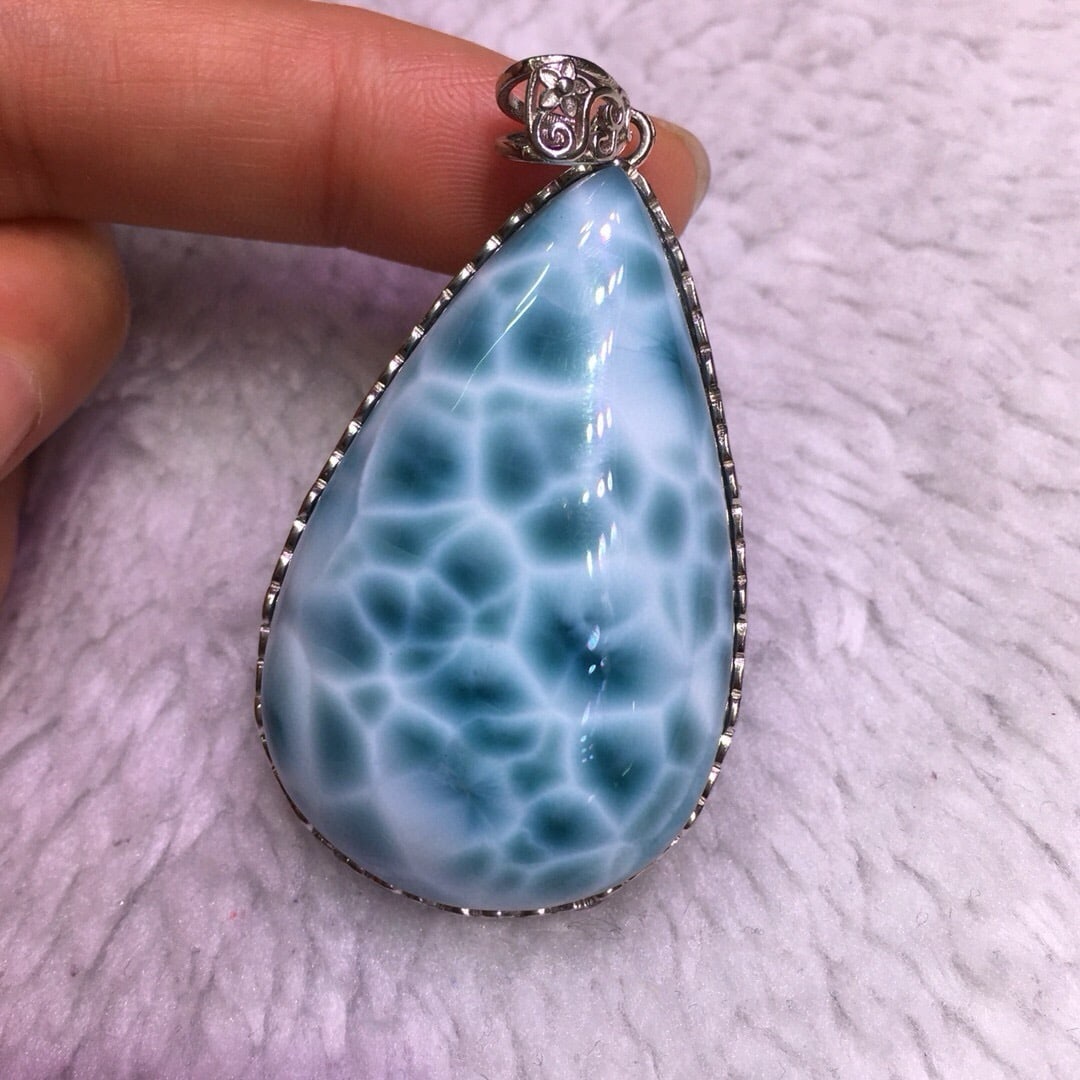 Sterling Silver Natural Larimar Pendant: This pendant is meticulously set in sterling silver, showcasing a Larimar with full turtle patterns, where unique textures and colors intertwine, reminiscent of ocean waves. Its elegant design