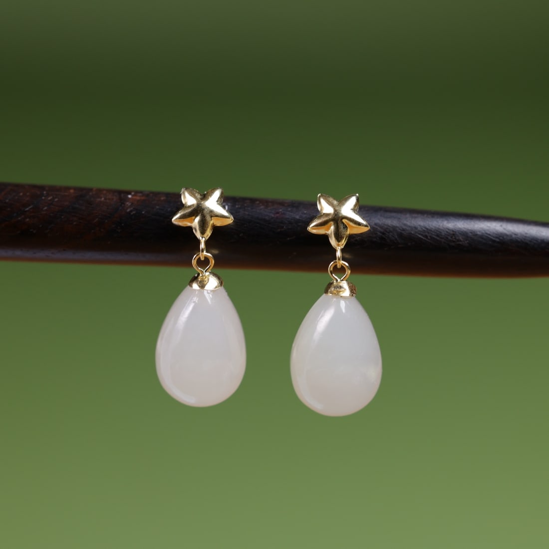18K Gold Natural Hetian Jade White Jade Earrings: These earrings are meticulously set in 18K gold with natural Hetian jade white jade, featuring an elegant teardrop shape that showcases unique luster and texture. Each jade stone is carefully selected
